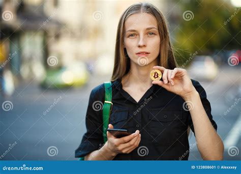 Young Woman With Coin Bitcoin And Smartphone In Hand On The Back Stock