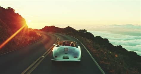 Happy Couple Driving On Country Road Into The Sunset In Classic Vintage
