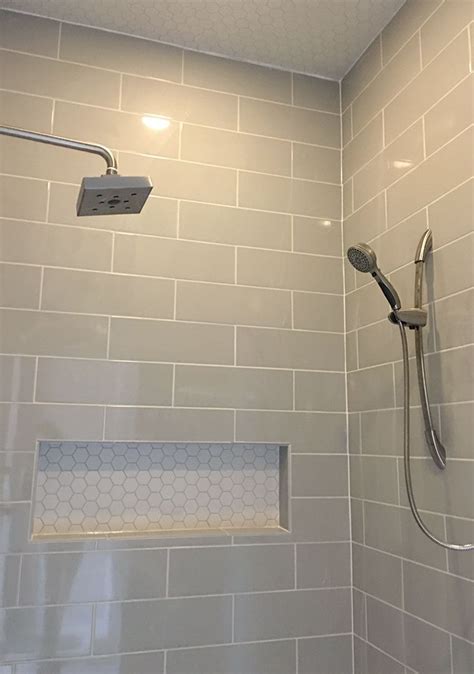 Tile layout is king in any bathroom renovation. Linear light gray shower wall tile with hexagon mosaic ...