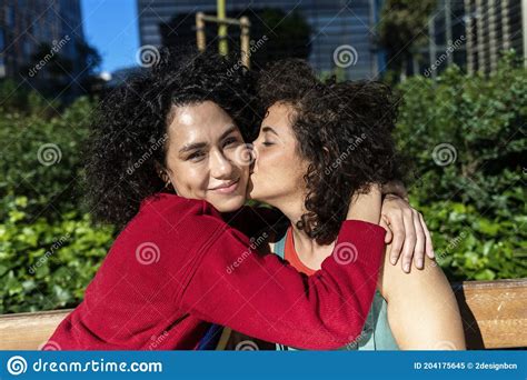 Smiling Lesbian Couple Embracing And Relaxing On A Park Bench Stock Image Image Of Lesbian