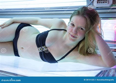 mujer en bikini en cama que broncea en solarium foto de archivo libre de regalías imagen 38141325