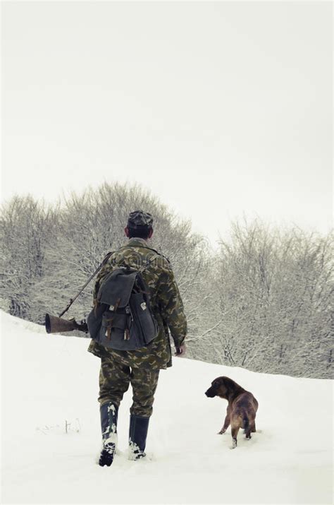 Man Hunting With A Dog In The Forest In Winter Editorial Stock Photo