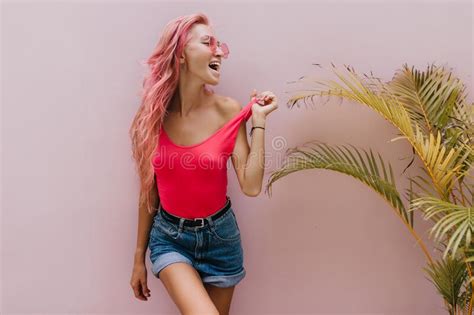 Beautiful Tanned Woman Playfully Posing Beside Palm Tree And Laughing