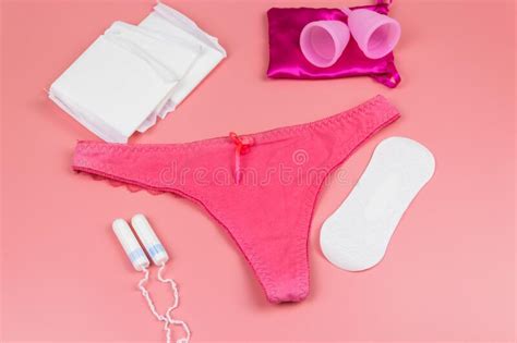 women`s panties with menstrual cups sanitary pads and tampons on pastel pink background top