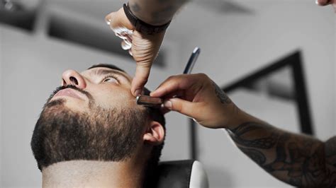 Barber Shaves Customer With Straight Razor Blade Mans Haircut And Shaving At The Hairdresser
