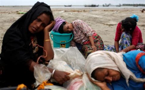 Exhausted Rohingya Refugees Rest On The Shore After Crossing The
