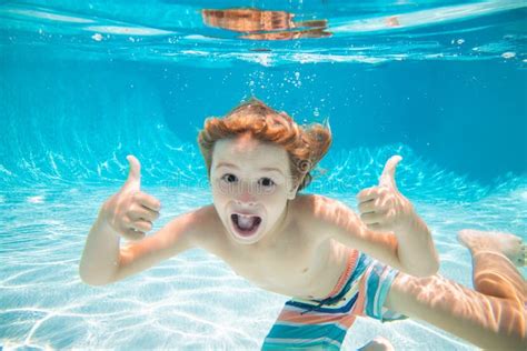 Happy Kid Boy Swim And Dive Underwater Kid With Thumbs Up In Swimpool