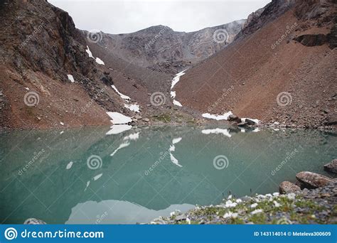Reflection Of A Mountain Landscape In The Turquoise Water Of A Lake