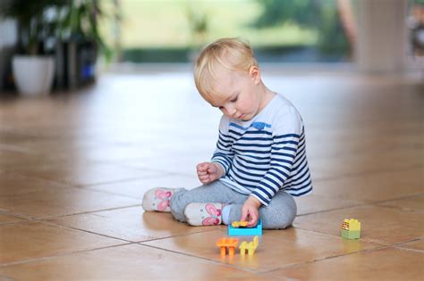 Cute little baby girl play with plastic bricks sitting  