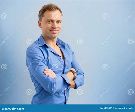 Portrait Of Young Smiling Handsome Man Standing With Arms Crossed Stock