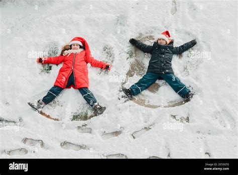 The Cute Little Kids Make Snow Angel On The Ground Stock Photo Alamy