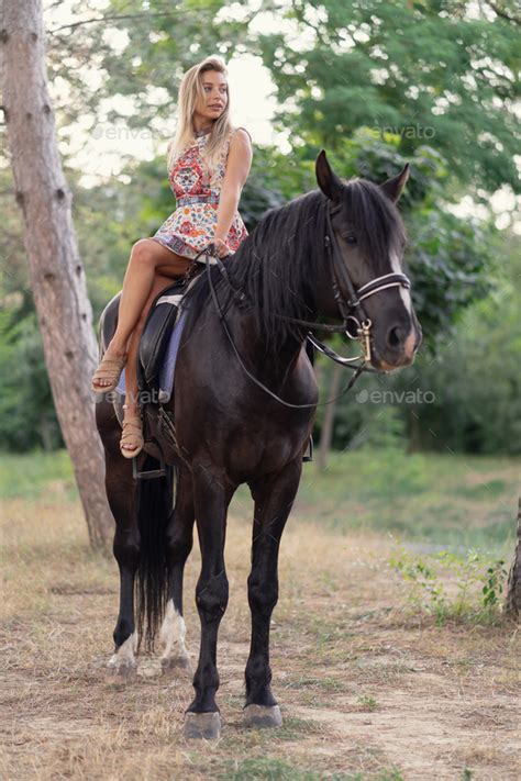 young woman   bright colorful dress riding  black horse stock photo  arthurhidden