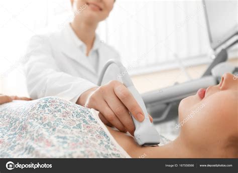 Doctor Conducting Ultrasound Examination Of Woman In Clinic Closeup
