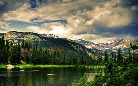 Body Of Water Near Green Trees And Mountains Under Blue Sunny Cloudy