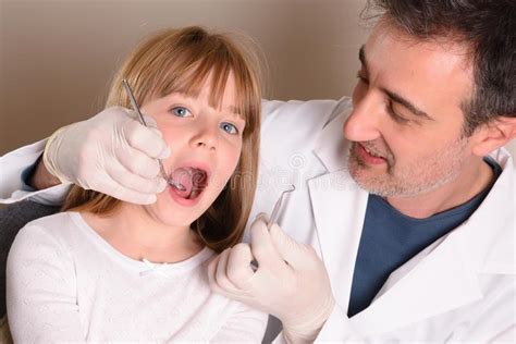 Pediatric Dentist Checking The Mouth Of A Girl Elevated View Stock