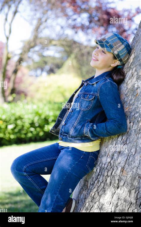 Tween Girl Leaning Against Tree In Park Stock Photo Alamy