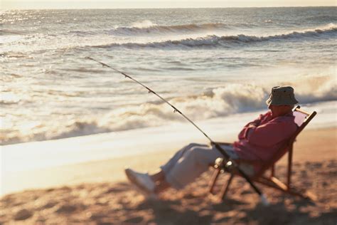 Senior Man Sitting On A Beach Chair With A Fishing Rod 爆釣速報