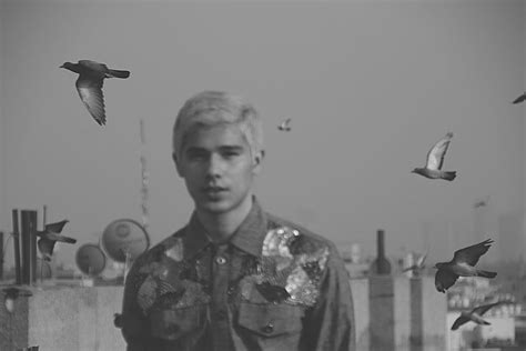 A Black And White Photo Of A Man Surrounded By Birds In The Air With