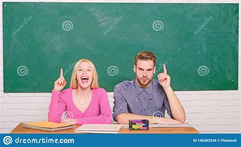 Guy And Girl Sit At Desk In Classroom Correct Answer On Their Mind