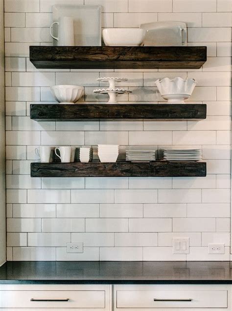 Kitchen With Chunky Wood Floating Shelves Filled With White Pottery