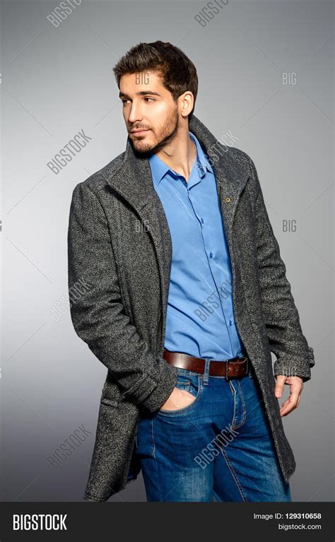 Handsome Man Wearing Jeans Clothes And A Coat Posing At Studio Mens