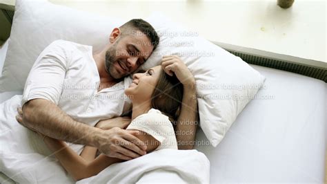 Young Beautiful And Loving Couple Talk And Hug Into Bed While Waking Up