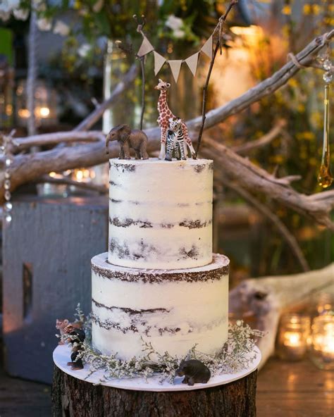 A Three Tiered Cake Decorated With Giraffes And Stars Is On Top Of A