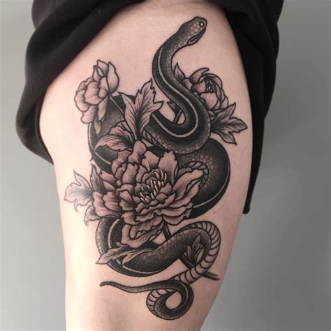 A coiled snake tattoo shows the world that you have a deadly persona lurking underneath your seemingly composed and collected exterior. by Baylen Levore #flowers #snake #legs | Floral thigh ...