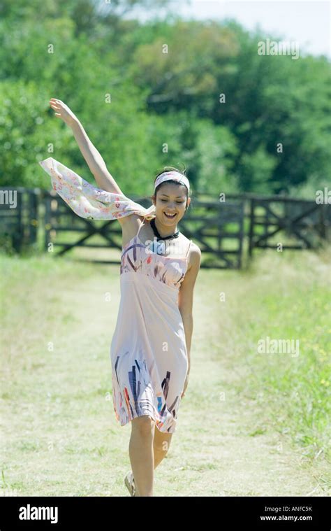 Young Woman Running Along Rural Path Arm Raised Stock Photo Alamy