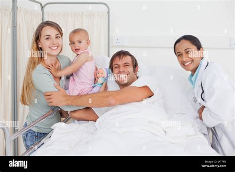 Smiling Family Hugging In A Hospital Room While A Doctor Is Next To Them Stock Photo Alamy