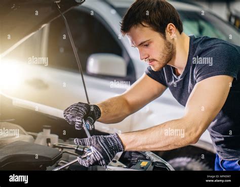 Auto Mechanic Working Under Car Hood In Repair Garage Stock Photo Alamy