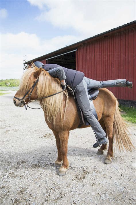 Mature Woman Mounting Horse Stock Photo