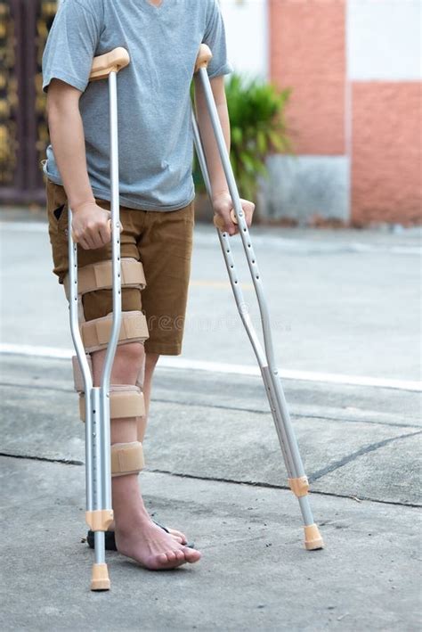 Disabled Woman With Crutches Or Walking Stick Or Knee Support Standing