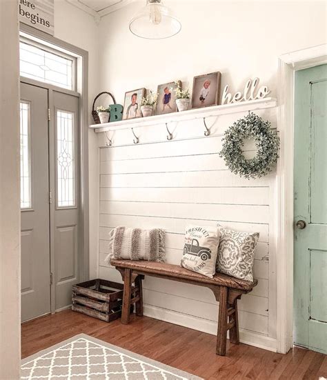 A Row Of Silver Coat Hooks Are Mounted On White Shiplap Wainscoting