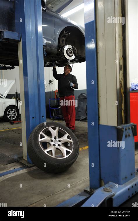 Car Mechanic Checking A Car Raised On A Hydraulic Lift Stock Photo Alamy