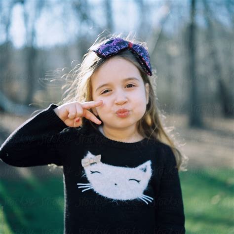 Cute Young Girl Making A Duck Face And A Sign With Her Hand By Jakob