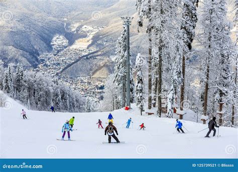 Skiers And Snowboarders Ride On Ski Slope In Sochi Mountain Ski Resort
