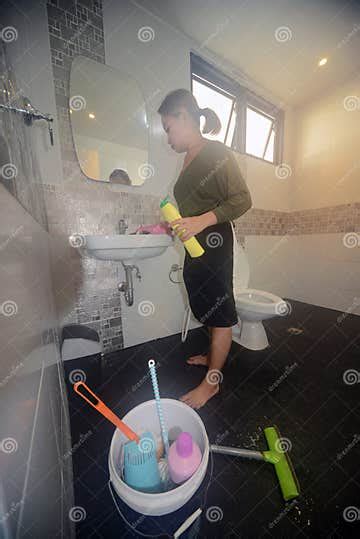 Asian Female Maid Or Housekeeper Cleaning On Lavatory In Toilet Stock