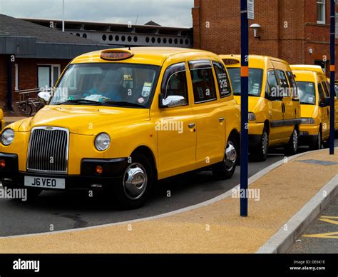 Yellow Taxis Parked On A Taxi Rank Outside Derby Railway Station Stock