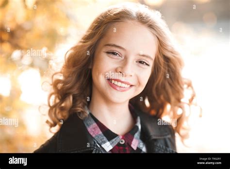 laughing jovencita de 12 a 14 años posando al aire libre sobre la naturaleza de fondo mirando a