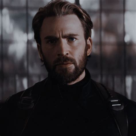 A Man With A Beard Wearing A Leather Jacket And Looking At The Camera