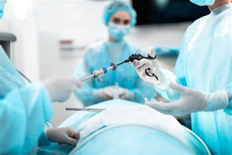 Nurse Giving Laparoscopic Instrument To Doctor During Surgical