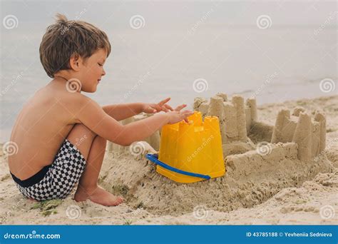 Bambino Che Fa I Castelli Della Sabbia Alla Spiaggia Fotografia Stock Immagine Di Castello