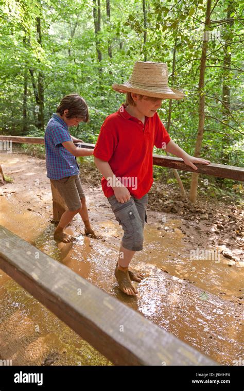 Boys Walking Through Mud At Barefoot Trail Egestorf Lower Saxony