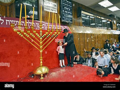 An Orthodox Jewish Rabbi Lights Hanukkah Candles As Students And