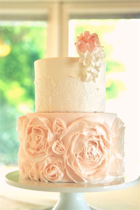 Wedding Cake With Pink Rosettes And Intricate Lace Detail With Sugar
