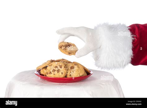 Santa Claus Reaching For A Fresh Chocolate Chip Cookie From A Red Plate