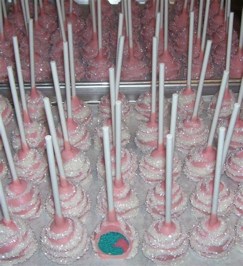 There Are Many Pink Desserts On The Table With White Sticks Sticking
