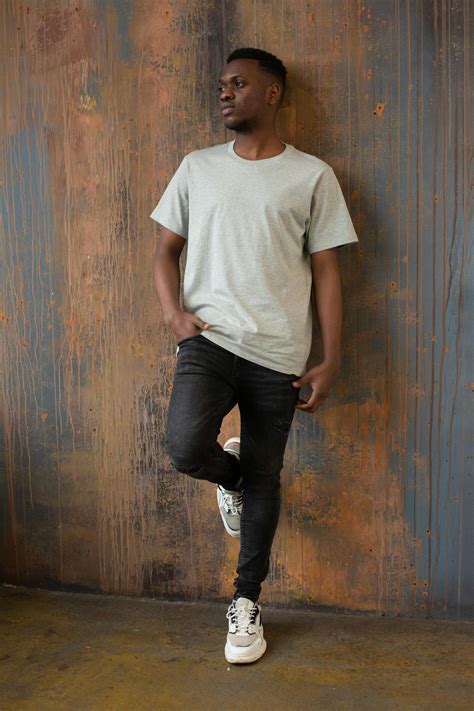 Serious Young Black Male Leaning On Wooden Wall And Looking Away