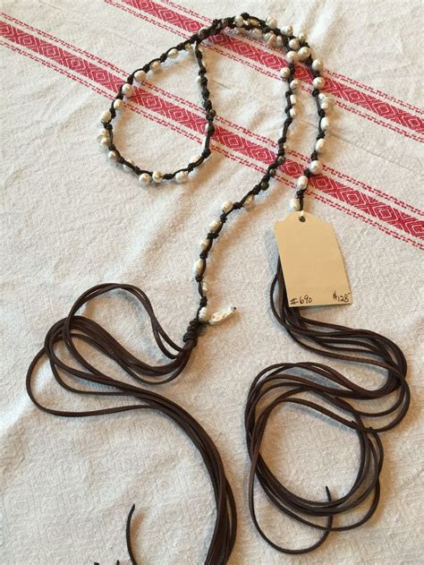 Two Necklaces Are Laying On A Bed With A Name Tag Attached To Them